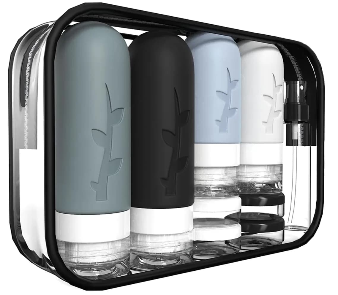 Travel bottles set in gray packed inside the clear toiletry bag