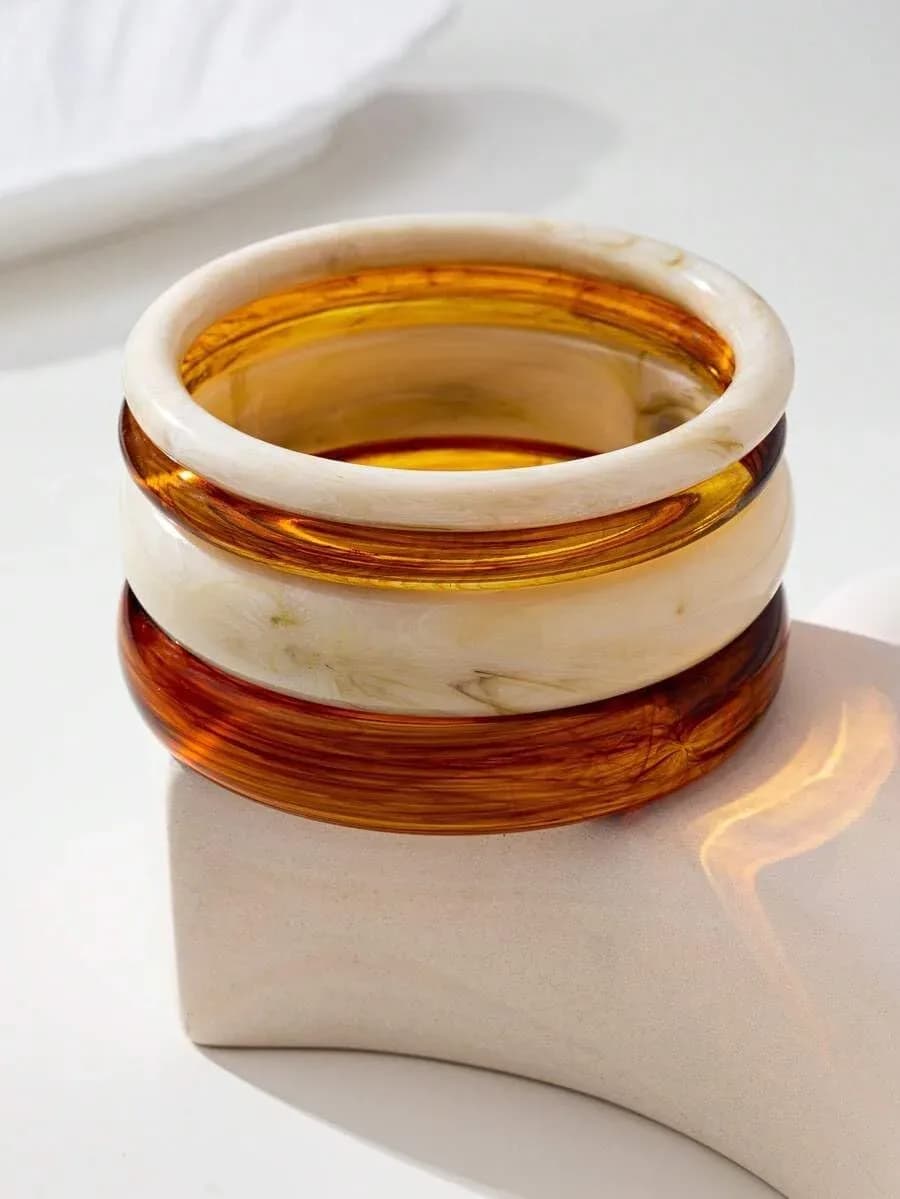 Chunky resin bangles stacked together in a tall layered pile